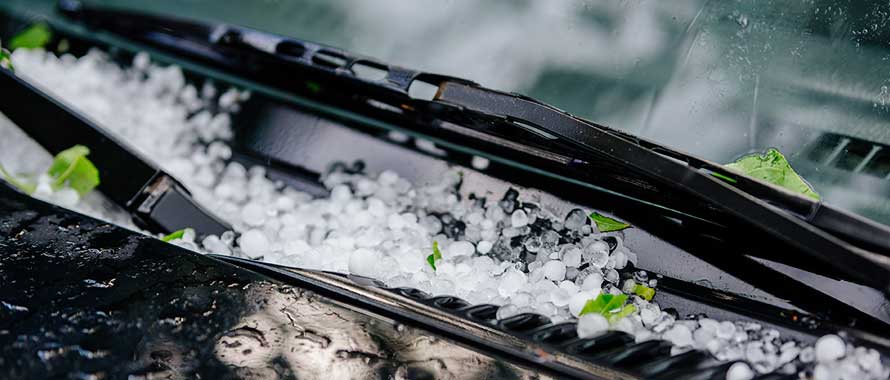 car at dealership covered in hail